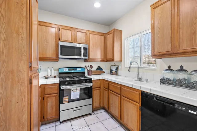 a kitchen with stainless steel appliances granite countertop white cabinets a sink and a stove