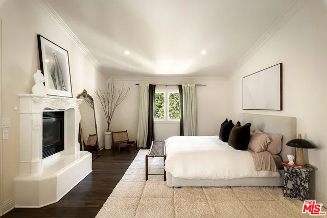 a bedroom with a large bed and a fireplace