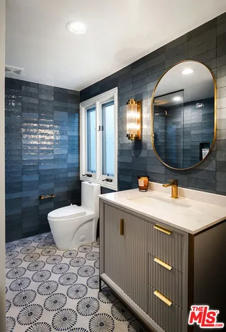 a bathroom with a sink a toilet and mirror