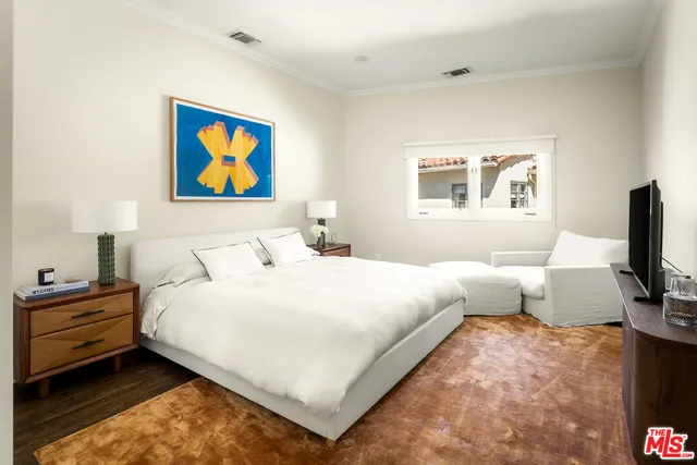 a bedroom with a bed and a flat screen tv