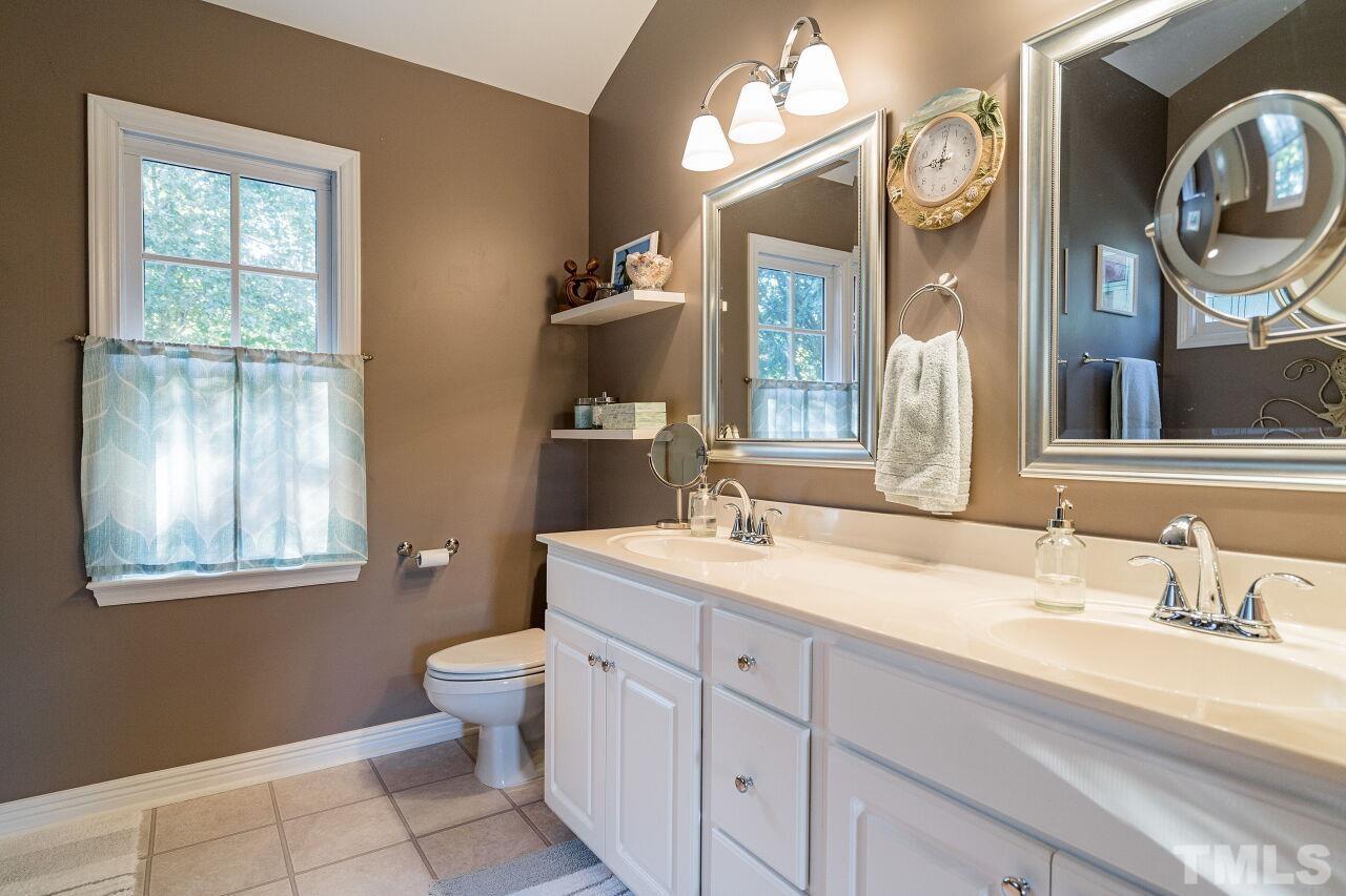 2201 Dunlin Lane Raleigh, NC 27614 - Photo 17 of 30 a bathroom with a toilet a sink and mirror