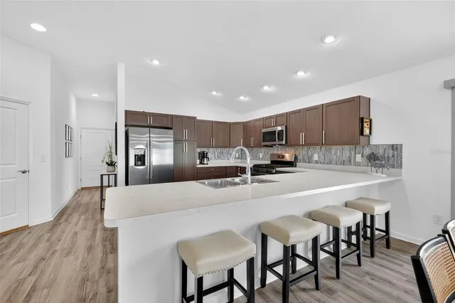 a large kitchen with kitchen island a dining table and chairs