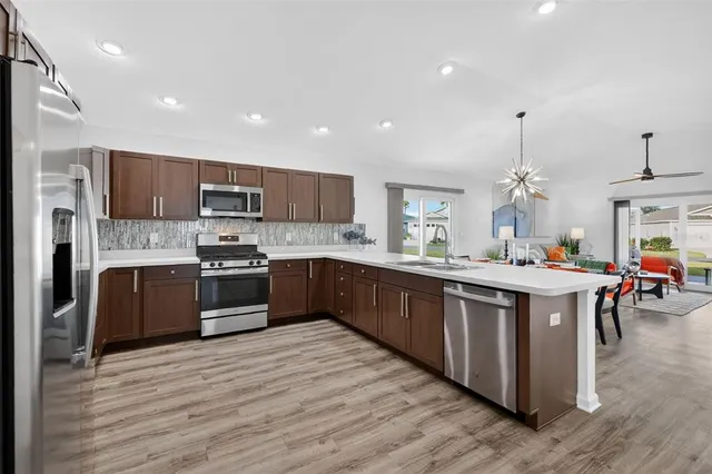 a large kitchen with stainless steel appliances and a wooden floors