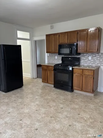 a kitchen with stainless steel appliances granite countertop a stove a refrigerator a sink and dishwasher