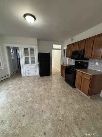 a view of kitchen with furniture and electronic appliances