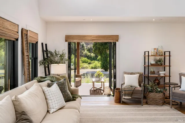 a kitchen with stainless steel appliances granite countertop a stove top oven a refrigerator a sink and chairs