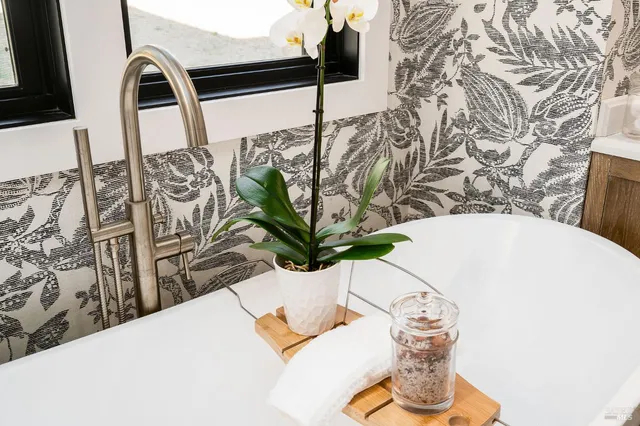 a view of a patio with table and chairs under an umbrella with a small yard