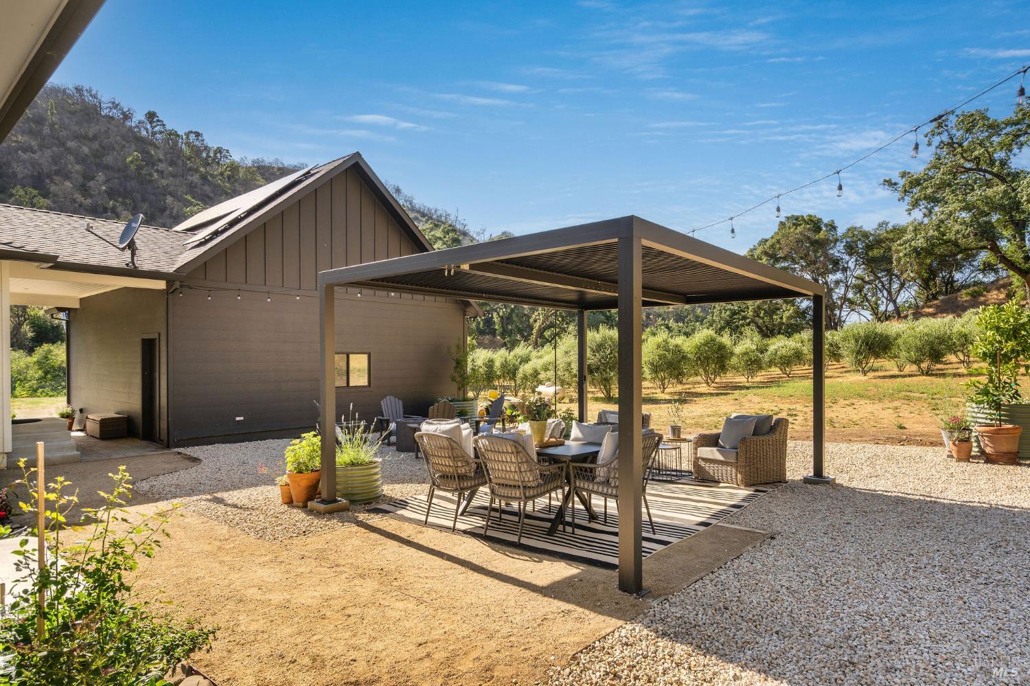 5400 Wragg Canyon Road Napa, CA 94558 - Photo 49 of 68 a view of a patio with table and chairs under an umbrella with a small yard