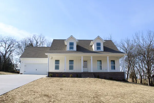 a front view of a house with a yard and covered with snow