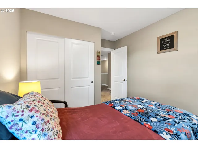 a bedroom with a bed and a painting on the wall