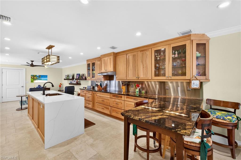 4030 Crayton Road, Unit C2 Naples, FL 34103 - Photo 12 of 32 a open kitchen with stainless steel appliances kitchen island granite countertop a table and chairs
