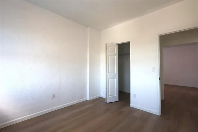 an empty room with wooden floor and closet
