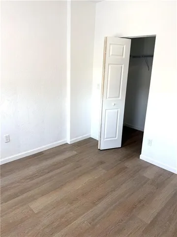 an empty room with wooden floor and closet