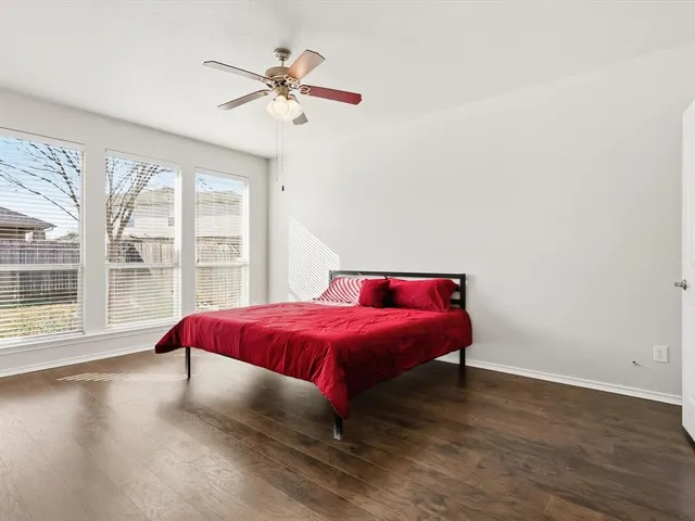 a spacious bedroom with a bed and a large window