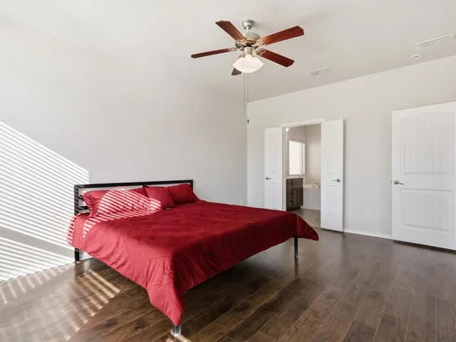a bedroom with a large bed and a chandelier