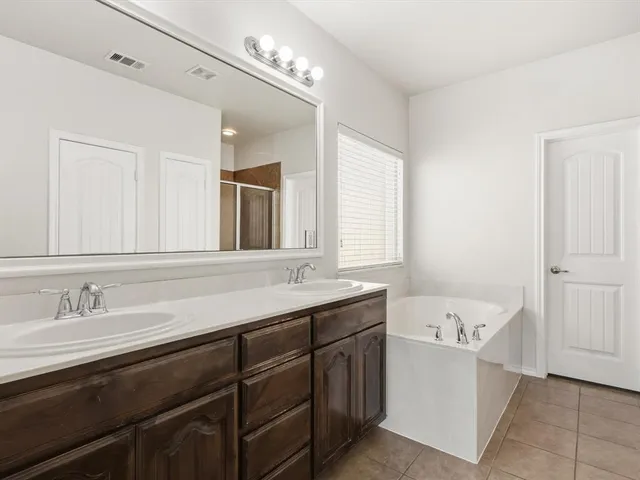 a bathroom with a tub sink and mirror