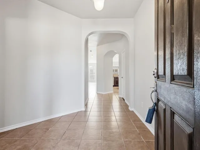 a hallway with white doors wooden floor and glass door
