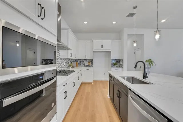 a large kitchen with stainless steel appliances lots of counter space sink and cabinets