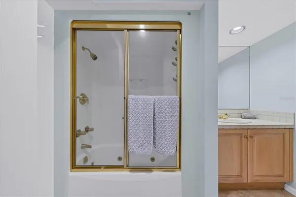 a bathroom with a glass shower door and a sink