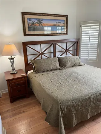 a bedroom with a bed a dresser and next to a window