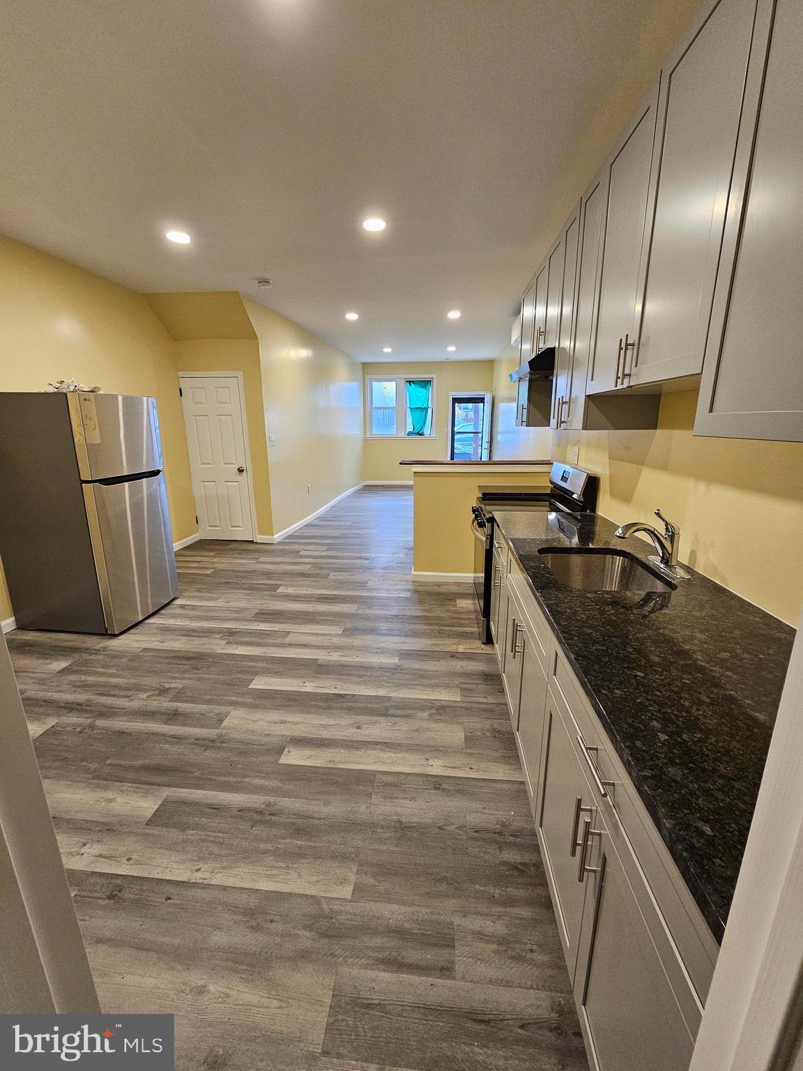 1535 North 60th Street, Unit A Philadelphia, PA 19151 - Photo 2 of 11 a large kitchen with stainless steel appliances granite countertop a sink and a stove