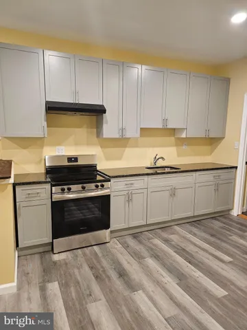 a kitchen with a sink stove and cabinets