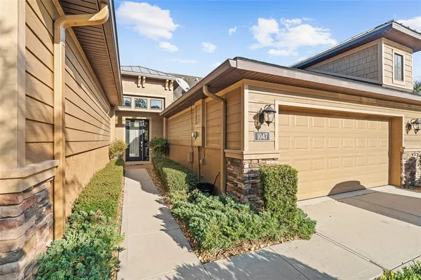 a yellow house with flower garden in front of it
