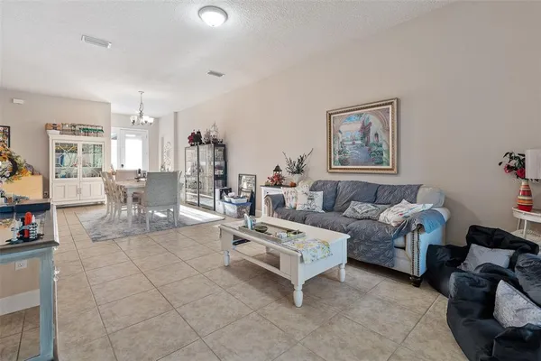 a living room with furniture and a view of kitchen