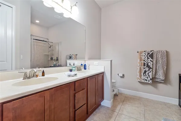 a bathroom with a double vanity sink mirror and toilet
