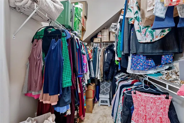 a view of walk in closet with clothes and shoes