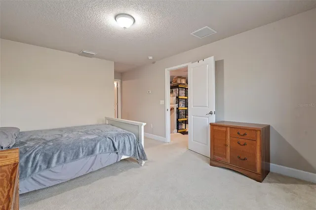 a spacious bedroom with a bed and a cabinets