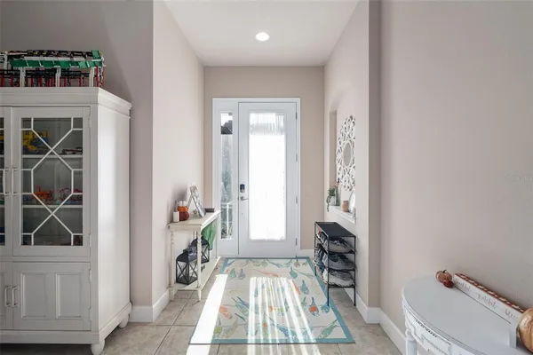 a view of a hallway to a livingroom with furniture wooden floor and front door