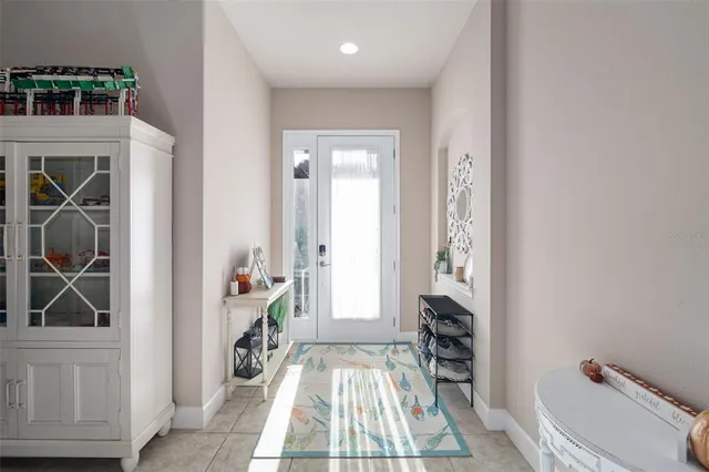 a view of a hallway to a livingroom with furniture wooden floor and front door