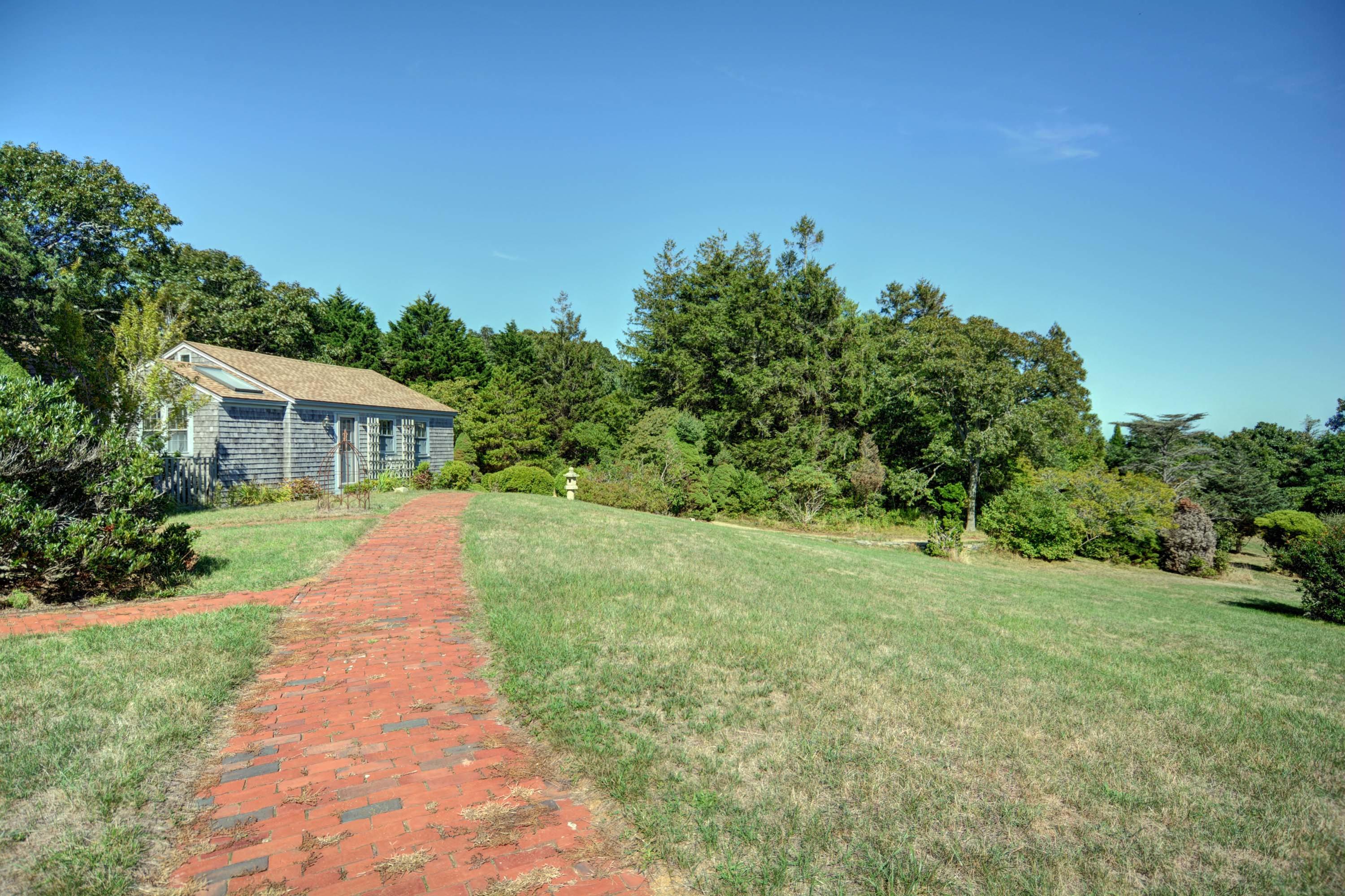 17 High Mark Road Chilmark, MA 02535 - Photo 36 of 52 a front view of a house with a yard and trees
