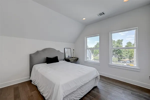 a large bed sitting in a bedroom next to a window