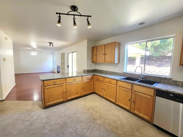 a large kitchen with kitchen island granite countertop a sink window and cabinets