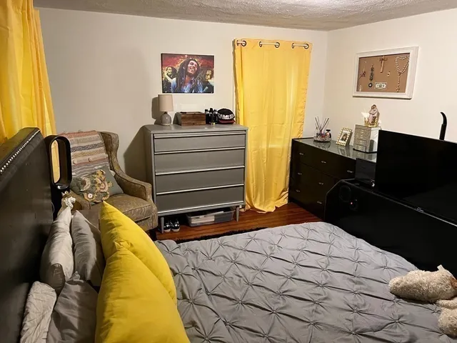 a bedroom with a bed and wooden floor