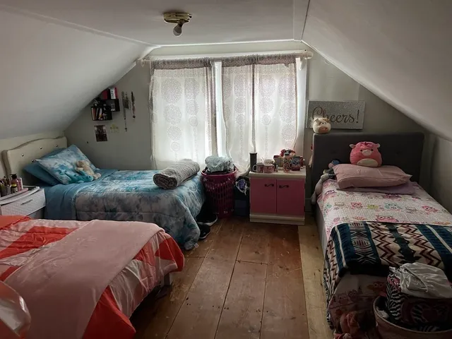 a bedroom with two beds and a large window