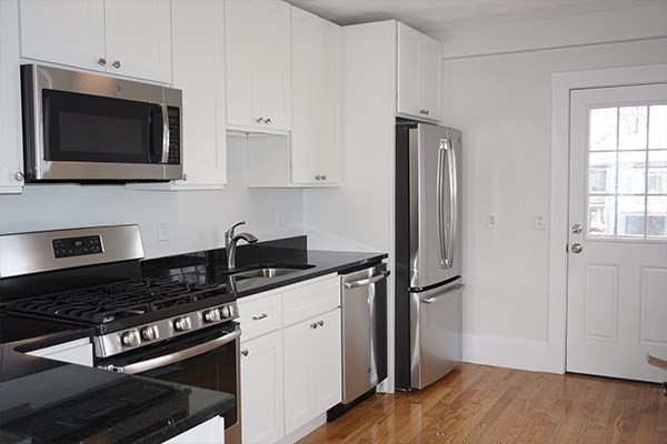 252 Ash Street, Unit 4 Waltham, MA 02453 - Photo 5 of 13 a kitchen with a stove and a microwave