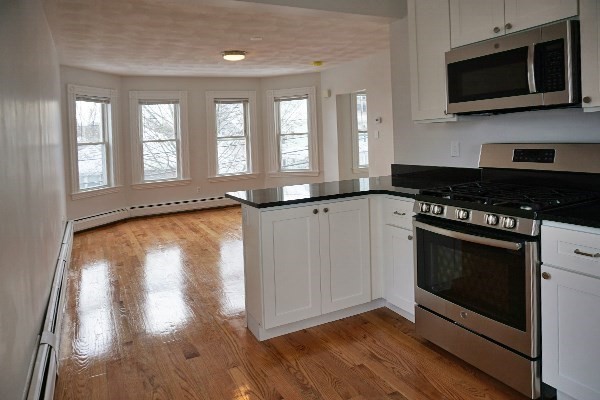 252 Ash Street, Unit 4 Waltham, MA 02453 - Photo 6 of 13 a kitchen with stainless steel appliances a stove microwave and sink