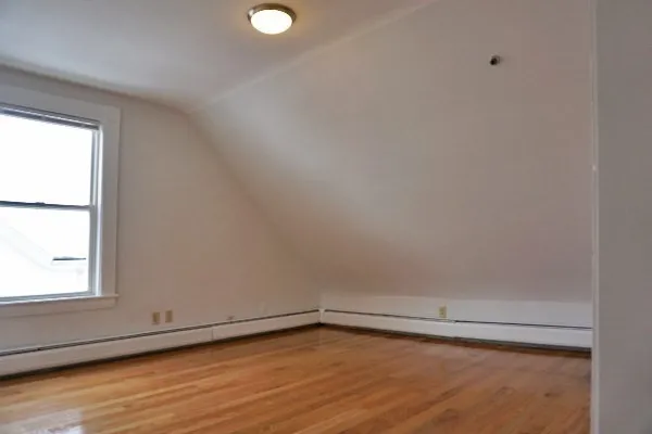 a view of a small space with wooden floor and a window