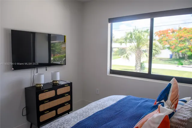 a bedroom with a bed that has a painting on the wall