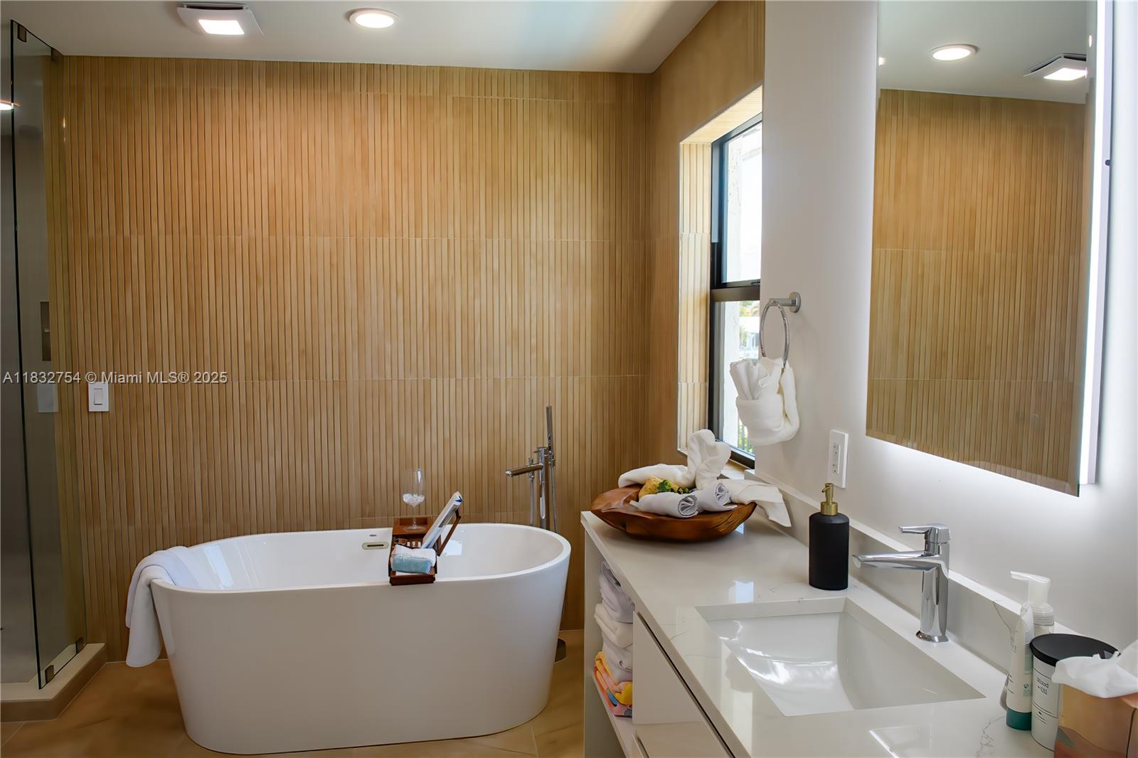 1240 Northeast 27th Terrace Pompano Beach, FL 33062 - Photo 19 of 98 a bathroom with a tub sink and a mirror