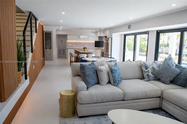 a living room with furniture flat screen tv and large window