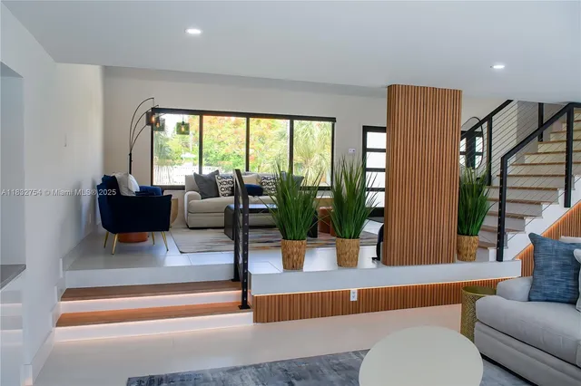 a living room with furniture and large windows