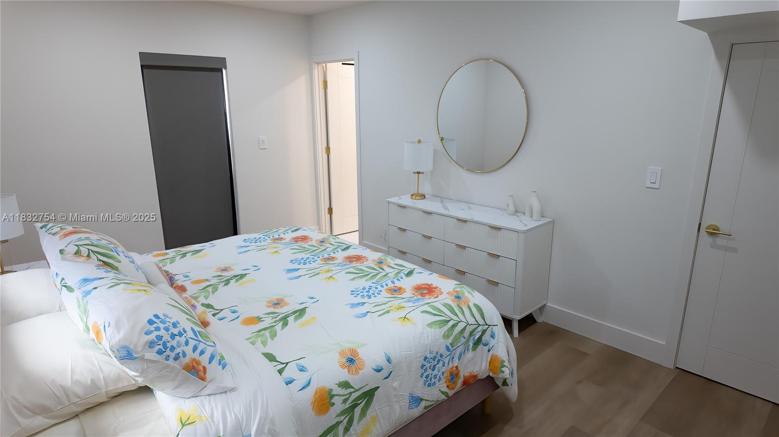 1240 Northeast 27th Terrace Pompano Beach, FL 33062 - Photo 61 of 98 a bedroom with a bed a dresser and a mirror