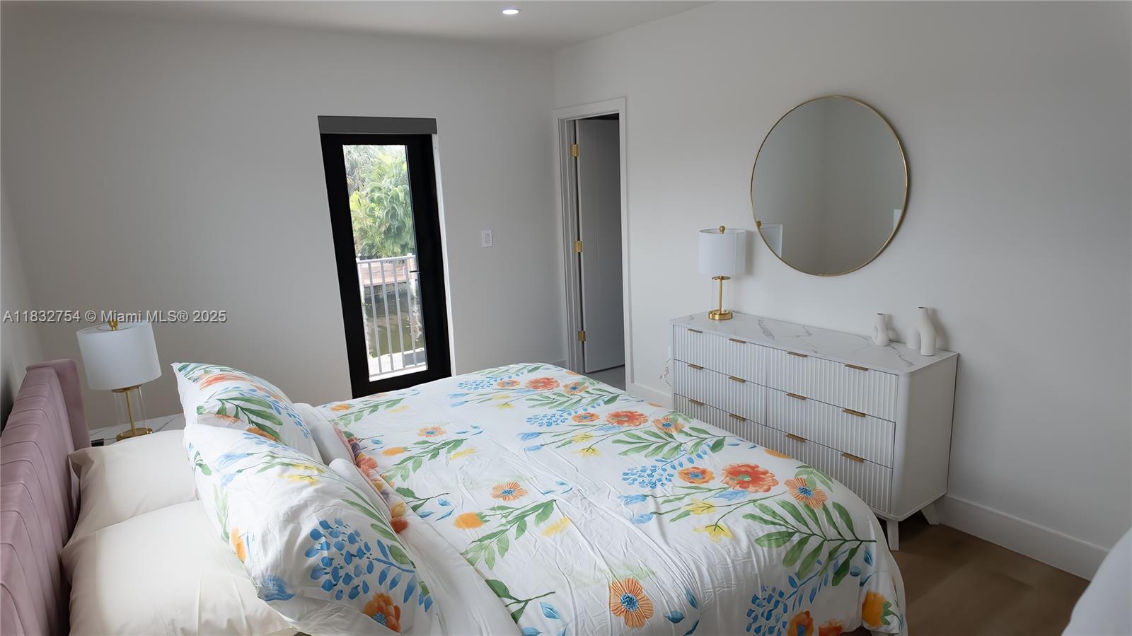 1240 Northeast 27th Terrace Pompano Beach, FL 33062 - Photo 64 of 98 a bedroom with a bed and a mirror