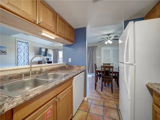 a kitchen with granite countertop a sink stove and cabinets