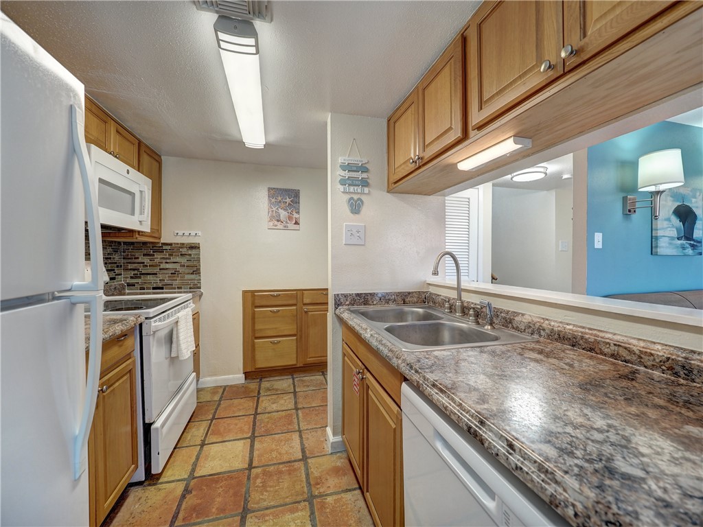 14300 Aloha Street, Unit 151 Corpus Christi, TX 78418 - Photo 14 of 33 a kitchen with granite countertop a sink stove and cabinets