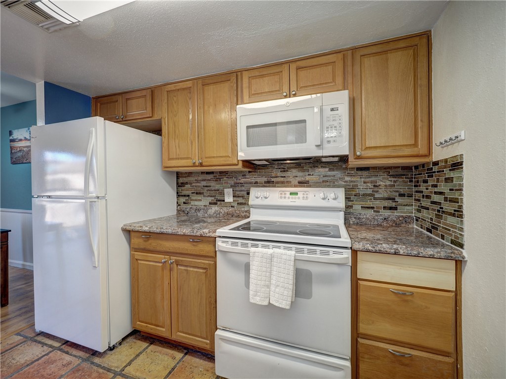 14300 Aloha Street, Unit 151 Corpus Christi, TX 78418 - Photo 15 of 33 a kitchen with a refrigerator stove and cabinets